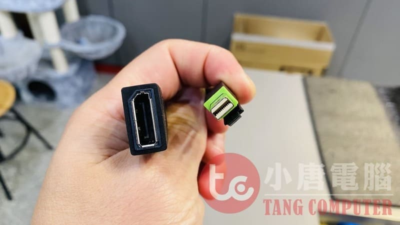 手持DisplayPort接頭與Mini DP接頭對比，展示不同尺寸的電腦螢幕傳輸介面