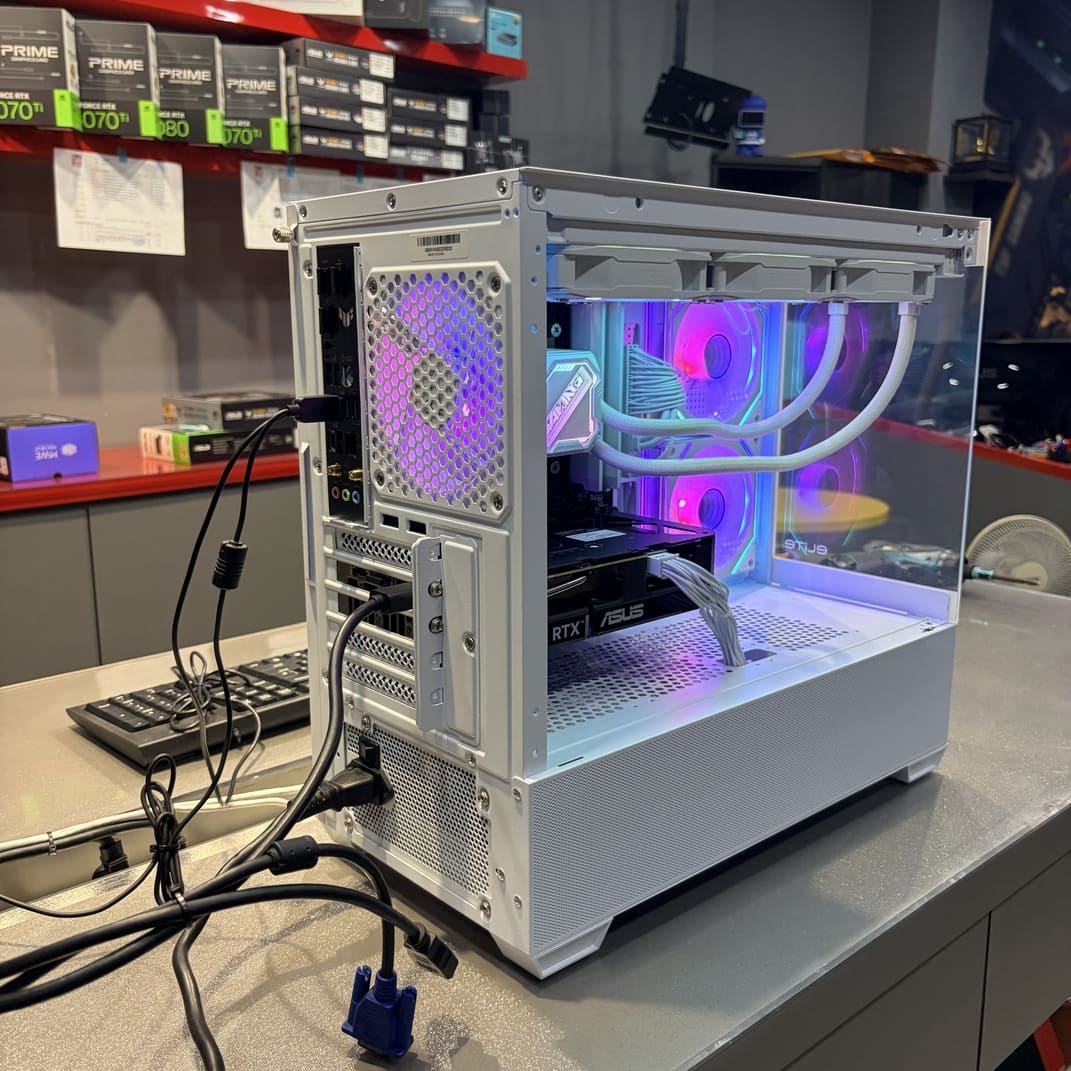 電腦主機後側視角，展示背部接口與白色電源