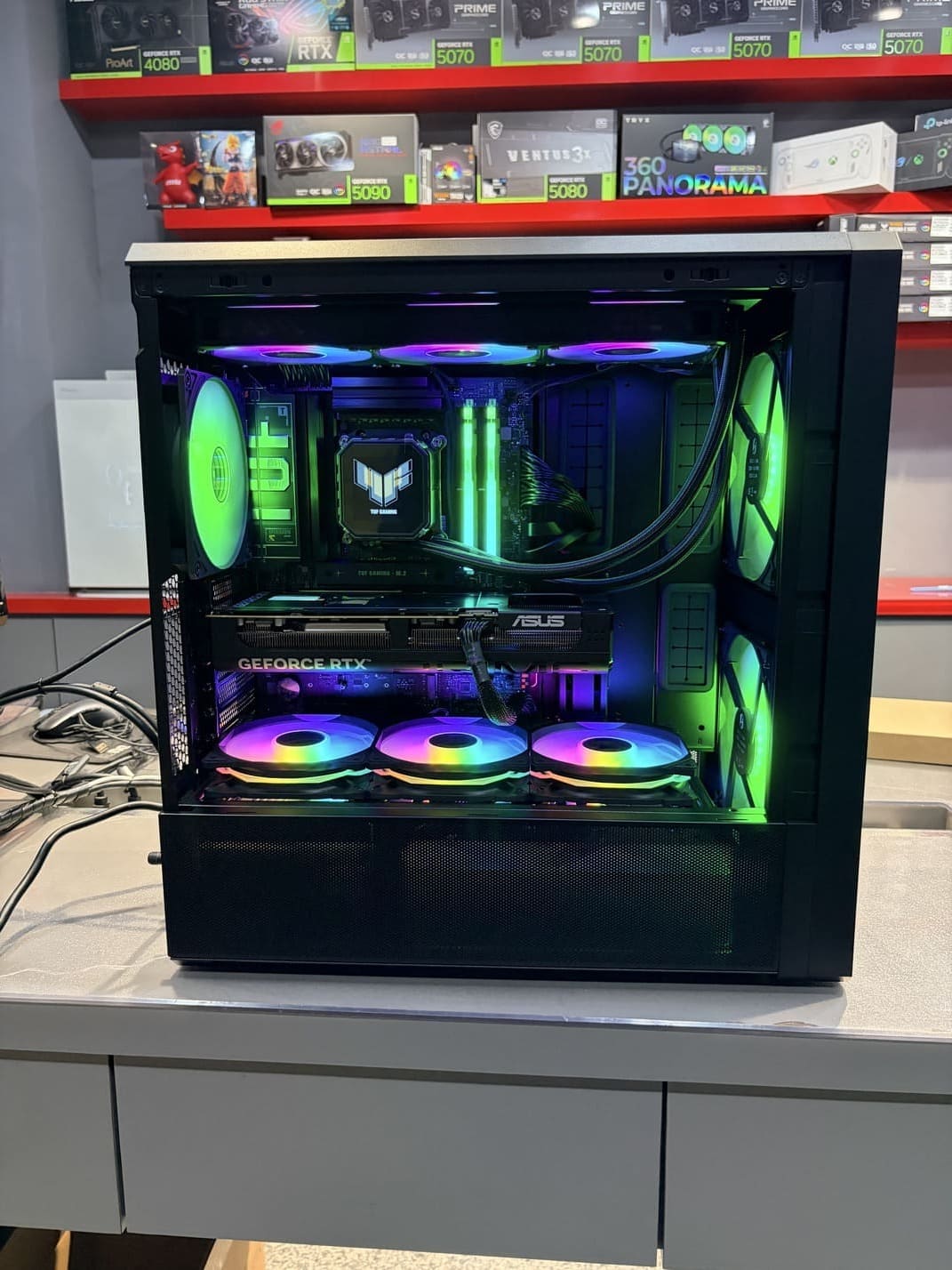 電腦主機側面全景，展示華碩 RTX 5080 顯卡與 TUF 水冷頭