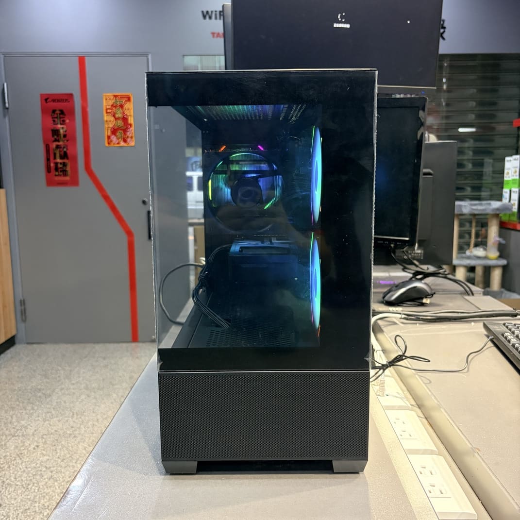 電腦側透全景圖，展示 AMD R7 7700 與 RTX 5060 Ti 組裝完成品，內部走線整潔，RGB 燈光柔和