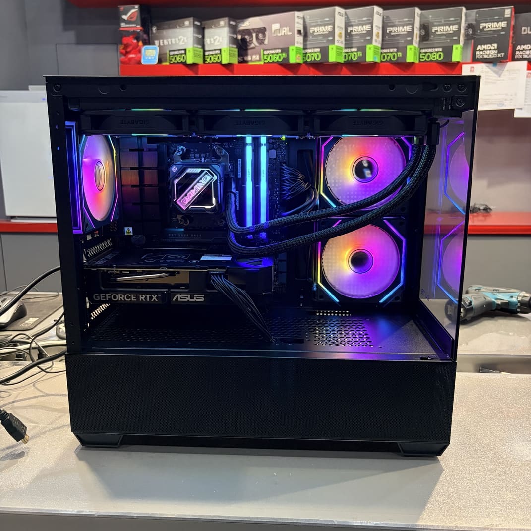 電腦內部側面特寫，展示 ASUS RTX 5060 Ti 顯卡安裝與水冷管走線