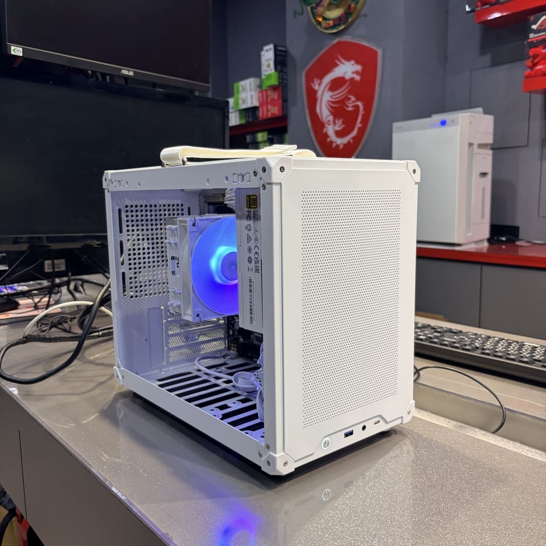 白色小電腦機殼側面展示，上方帶有提把，適合辦公室移動