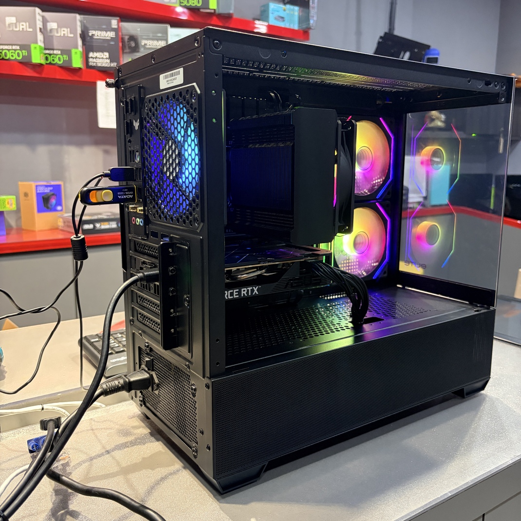 主機背面特寫，展示主機板 I/O 接口、後方排風扇與電源插座