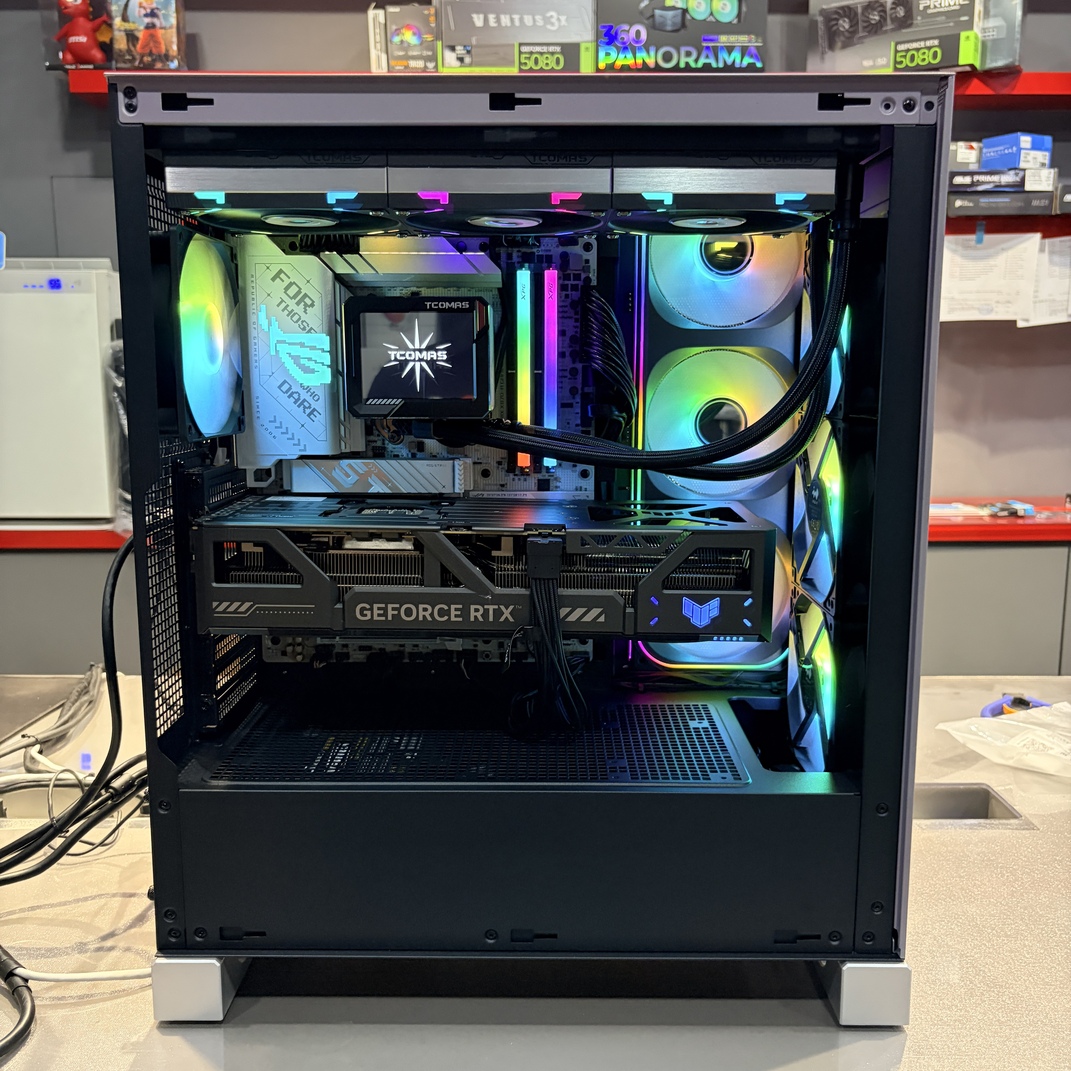 電腦機殼內部正面視角，展示 RTX 5090、ROG 主機板與 360 水冷