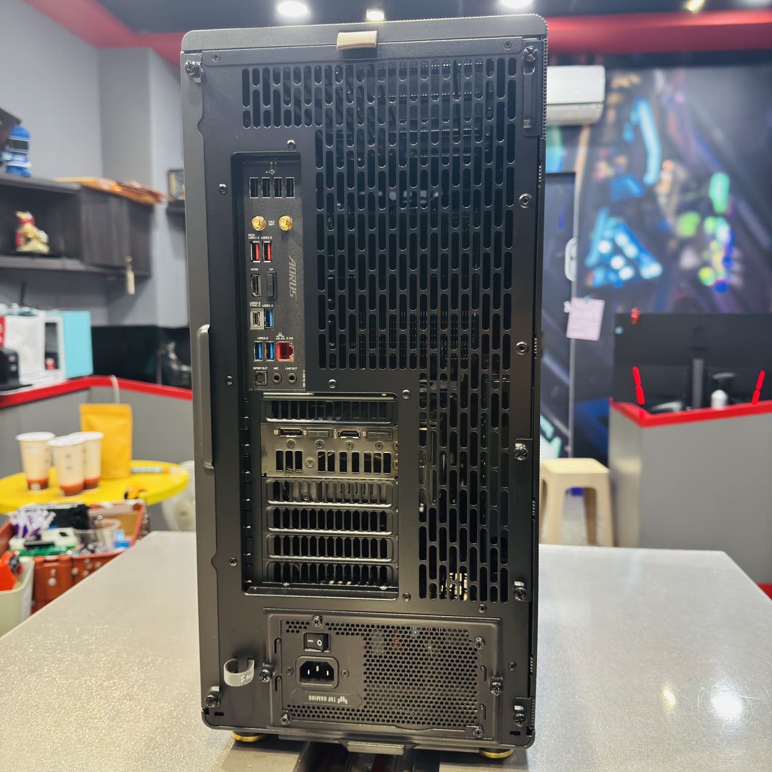 電腦機殼後方視圖，AORUS 主機板 IO 與顯卡接口