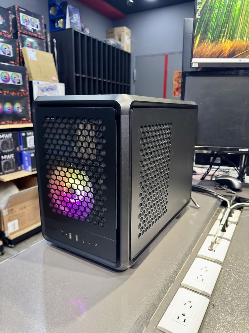 開機後的電腦主機正面，展示透過網孔透出的低調 RGB 燈效。